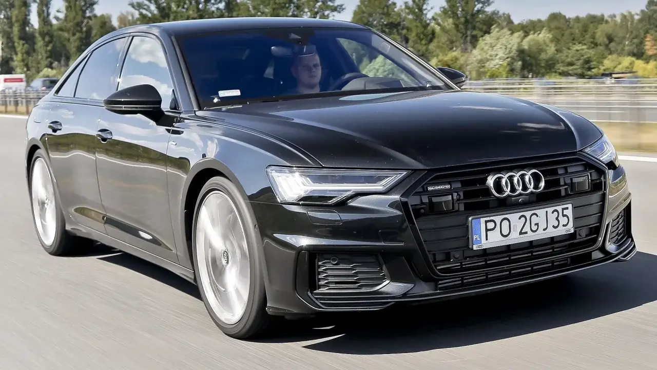 Czarny Audi A6 z silnikiem 3.0 TFSI pędzi autostradą, kierowca skupiony na drodze.