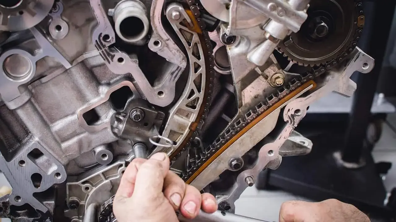 Mechanik pracuje przy rozrządzie silnika. Wymiana poduszki silnika może być konieczna, gdy pojawią się objawy takie jak wibracje.
