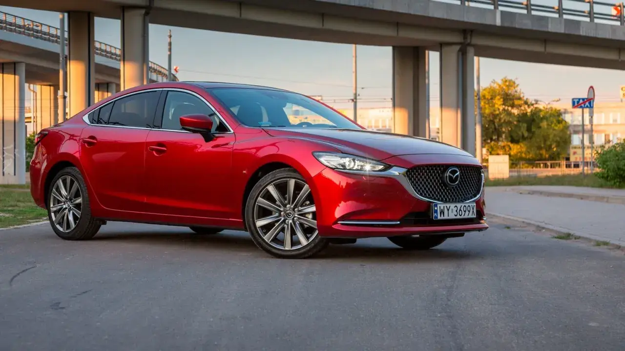 Czerwona Mazda 6 2.5 benzyna zaparkowana pod estakadą.