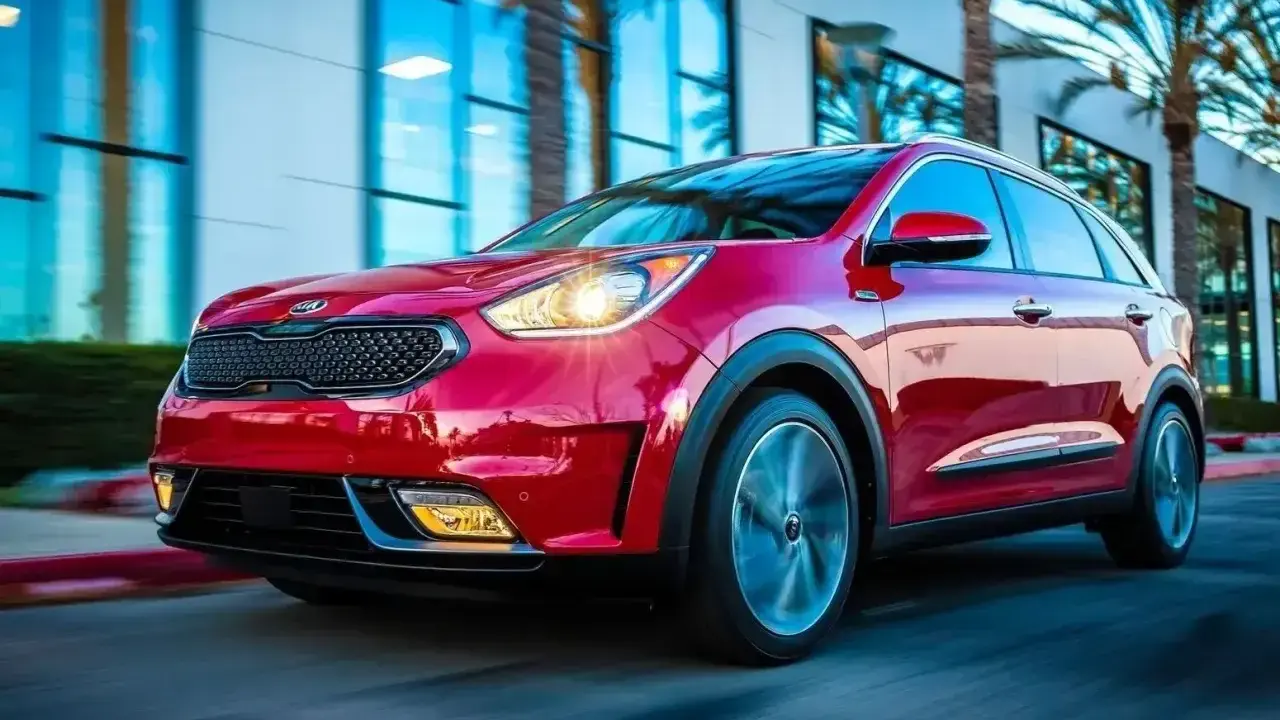 Czerwony Kia Niro w ruchu, z widocznymi światłami i felgami. Choć auto wygląda dynamicznie, warto rozważyć jego wady przed zakupem.