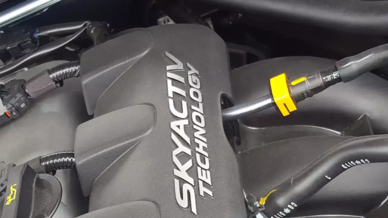 Silnik SKYACTIV TECHNOLOGY, jeden z najlepszych silników benzynowych, z widocznymi przewodami i złączkami.