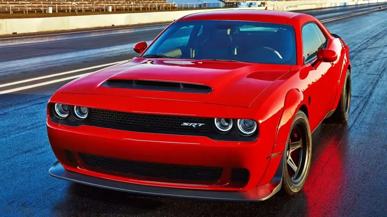 Czerwony Dodge Challenger Demon na torze wyścigowym, gotowy do startu.