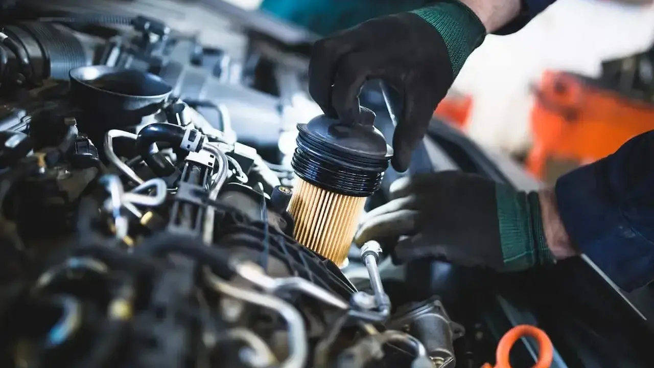 Mechanik wymienia filtr paliwa. Objawy jego zużycia mogą być różne, od spadku mocy po problemy z uruchomieniem silnika.