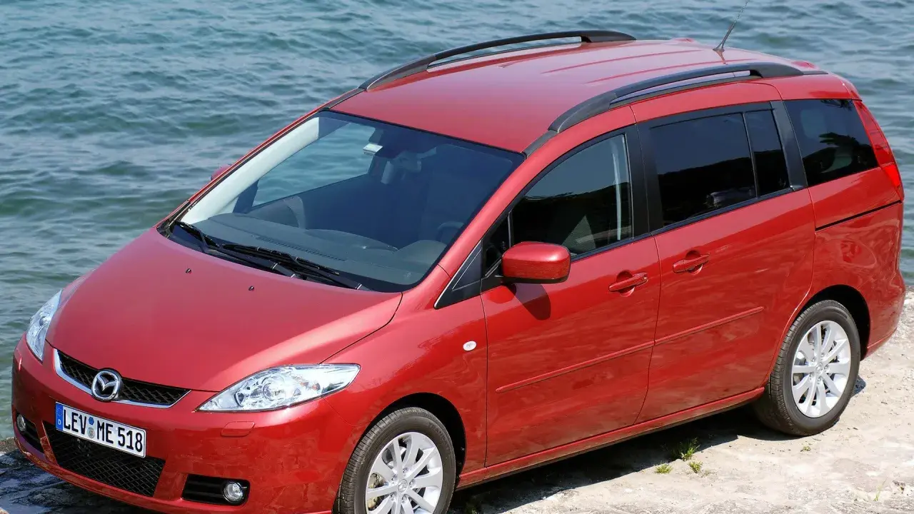 Czerwona Mazda 5 2.0 benzyna zaparkowana przy wodzie.