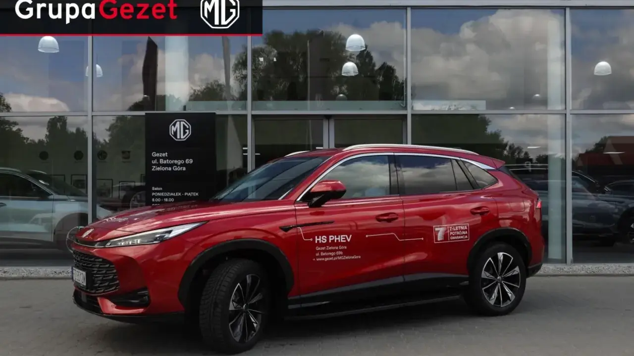 Czerwony MG HS PHEV przed salonem Gezet w Zielonej Górze. Warto sprawdzić ich ofertę, by wyrobić sobie opinię.