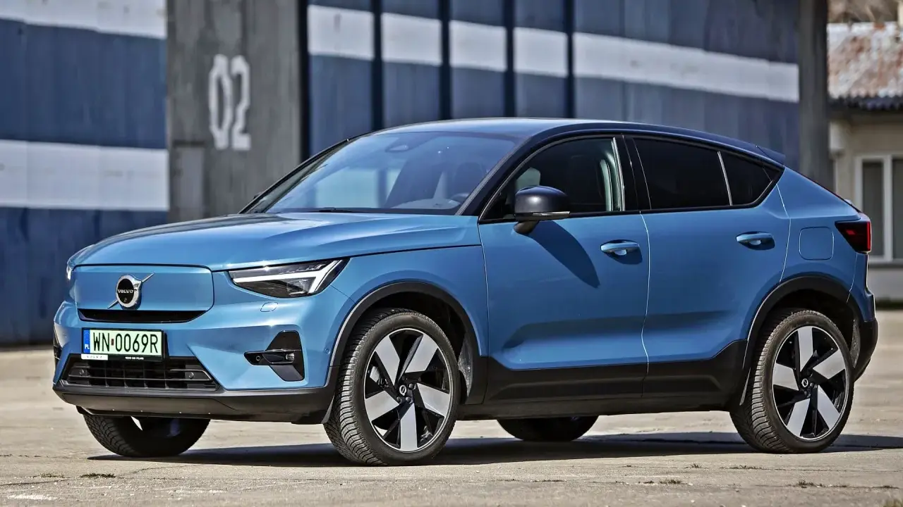Niebieskie Volvo C40 Recharge, elektryczny SUV, parkuje przed budynkiem z numerem 02.