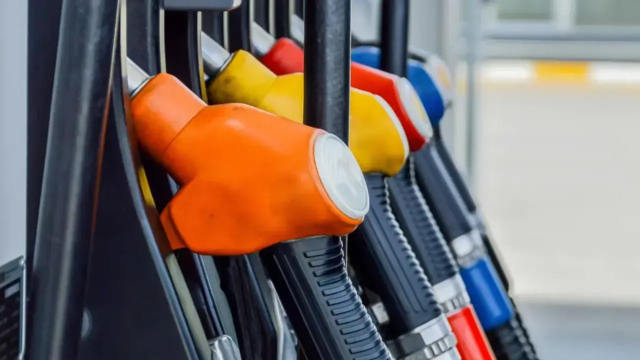 Kolorowe pistolety na stacji paliw, gotowe do tankowania. Jeden z nich, pomarańczowy, sugeruje, że można nim nalać verva diesel.
