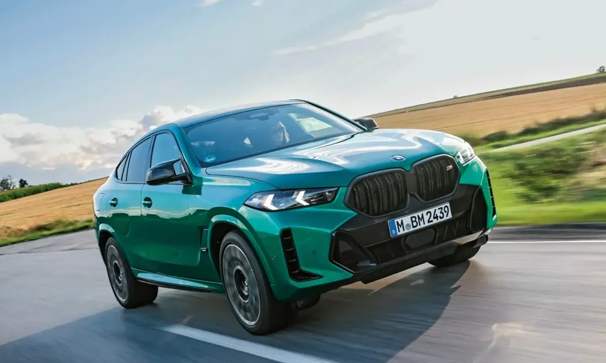 Zielony BMW X6 M Competition, jakby wyłaniał się z krajobrazu, niczym **formentor** w drodze na szczyt.