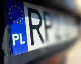 Zbliżenie na tablice rejestracyjne województwa z symbolem PL i gwiazdkami UE.