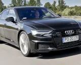 Czarny Audi A6 z silnikiem 3.0 TFSI pędzi autostradą, kierowca skupiony na drodze.