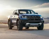 Niebieski Ford Ranger Raptor przemierza piaszczyste wydmy o zachodzie słońca.