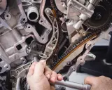 Mechanik pracuje przy rozrządzie silnika. Wymiana poduszki silnika może być konieczna, gdy pojawią się objawy takie jak wibracje.