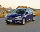 Niebieski Ford Focus MK3 1.6 TDCI na tle malowniczej hiszpańskiej wioski i gór.