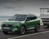 Zielony Ford Kuga z przyczepą i łodzią, idealny na wakacyjne wyjazdy. Sprawdź ford kuga cena!