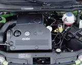 Silnik SDI Volkswagena, z widocznym logo i oznaczeniem, otoczony zieloną komorą silnika, akumulatorem i płynami eksploatacyjnymi.