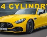 Żółty Mercedes-AMG GT 43 z napisem "4 CYLINDY" na tle szarego, rozmazanego tła.