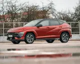 Nowy Hyundai Kona Hybrid w kolorze ognistej czerwieni, z czarnym dachem, prezentuje się dynamicznie na tle zimy.