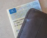 Dowód rejestracyjny pojazdu z PL i adresem Starostwa Czarnkowskiego, schowany w brązowym etui. Po rejestracja dokument gotowy do drogi.