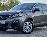 Szary Peugeot 3008 używany z salonu, z polskimi tablicami RP 5087A, zaparkowany na kostce brukowej.