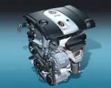 Silnik samochodowy 1.6 MPI z widocznymi paskami, alternatorem i osłoną z logo VW.