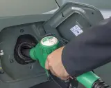 Tankowanie samochodu paliwem E5. Zielony pistolet dystrybutora wlewa paliwo do baku.