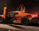 Pomarańczowy Lamborghini Revuelto z otwartymi drzwiami typu nożycowego, prezentujący sportowe wnętrze i agresywną sylwetkę.