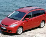 Czerwona Mazda 5 2.0 benzyna zaparkowana przy wodzie.