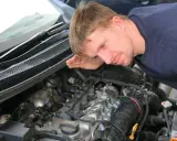 Mechanik nasłuchuje silnika, szukając oznak nieszczelnej odmy.