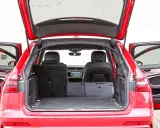 Czerwone Audi A6 Avant z otwartą klapą bagażnika i drzwiami. Wnętrze pokazuje przestronny bagażnik, idealny na wakacyjne wyjazdy, z możliwością powiększenia przestrzeni po złożeniu siedzeń.