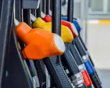 Kolorowe pistolety na stacji paliw, gotowe do tankowania. Jeden z nich, pomarańczowy, sugeruje, że można nim nalać verva diesel.
