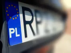 Zbliżenie na polską tablicę rejestracyjną z symbolem Unii Europejskiej i literami "PL".