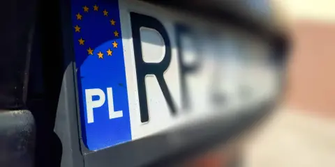 Zbliżenie na tablice rejestracyjne województwa z symbolem PL i gwiazdkami UE.