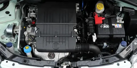 Silnik Fiata 500 L z widocznym logo FIAT na czarnej obudowie. Widać akumulator, płyny i elementy układu chłodzenia.