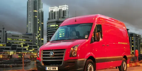 Czerwony Volkswagen Crafter 2.5 TDI na tle nocnego miasta.