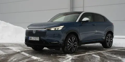 Ciemnoniebieski Honda HR-V na tle śniegu i szarej ściany.