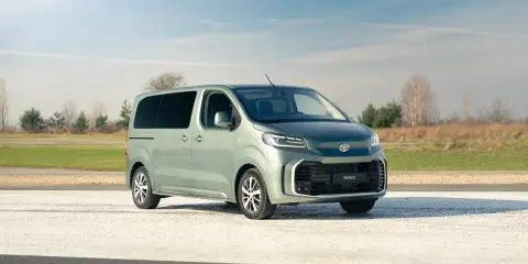 Nowy, zielony minivan Toyota Proace Verso na tle nieba i pól. Idealny na rodzinne wycieczki.