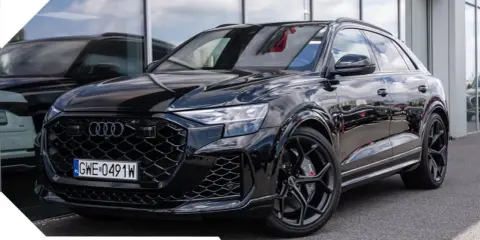 Czarny Audi RSQ8 lśni na tle salonu. Pakiet przeglądów gratis.