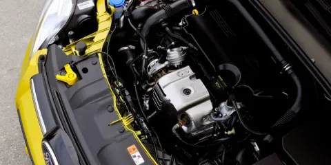 Silnik 1.0 Ecoboost w żółtym Fordzie. Widoczne elementy układu dolotowego, turbosprężarki i osłony silnika.