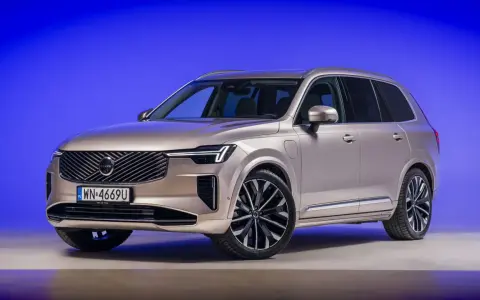 Eleganckie, nowe Volvo w kolorze szampańskim prezentuje się imponująco na tle niebieskiego tła.