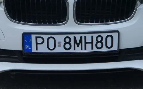 Tablice rejestracyjne sprawdzanie: polskie PO-8MH80 na białym samochodzie.