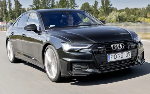 Czarny Audi A6 z silnikiem 3.0 TFSI pędzi autostradą, kierowca skupiony na drodze.