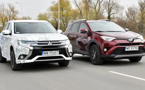Dwa SUV-y, biały Mitsubishi Outlander i czerwony Toyota RAV4, jadące po drodze. Idealne dla szukających najmniej awaryjne SUV-y 10 letnie.