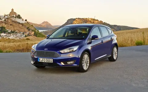 Niebieski Ford Focus MK3 1.6 TDCI na tle malowniczej hiszpańskiej wioski i gór.