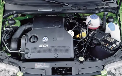 Silnik SDI Volkswagena, z widocznym logo i oznaczeniem, otoczony zieloną komorą silnika, akumulatorem i płynami eksploatacyjnymi.