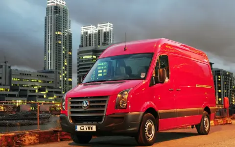 Czerwony Volkswagen Crafter 2.5 TDI na tle nocnego miasta.