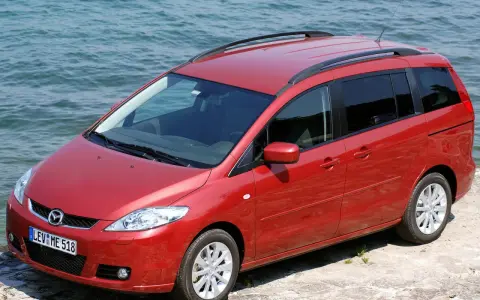 Czerwona Mazda 5 2.0 benzyna zaparkowana przy wodzie.