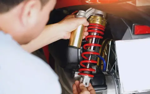 Mechanik wymienia amortyzator w skuterze. Sprawdź wymiana amortyzatorów cena i dowiedz się, ile kosztuje serwis.