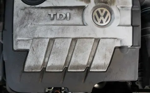 Silnik TDI 1.9 105 KM Volkswagena, pokryty kurzem i brudem, z widocznym logo TDI i VW.