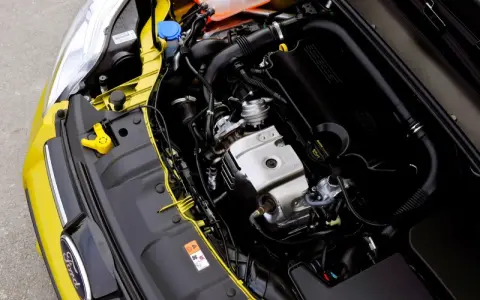 Silnik EcoBoost w żółtym Fordzie, z widocznym logo Ford i elementami układu dolotowego.