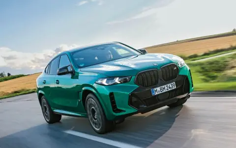 Zielony BMW X6 M Competition, jakby wyłaniał się z krajobrazu, niczym **formentor** w drodze na szczyt.